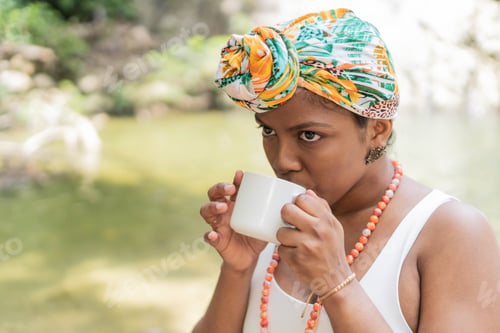 Preview: Black Woman enjoying morning coffee by the river