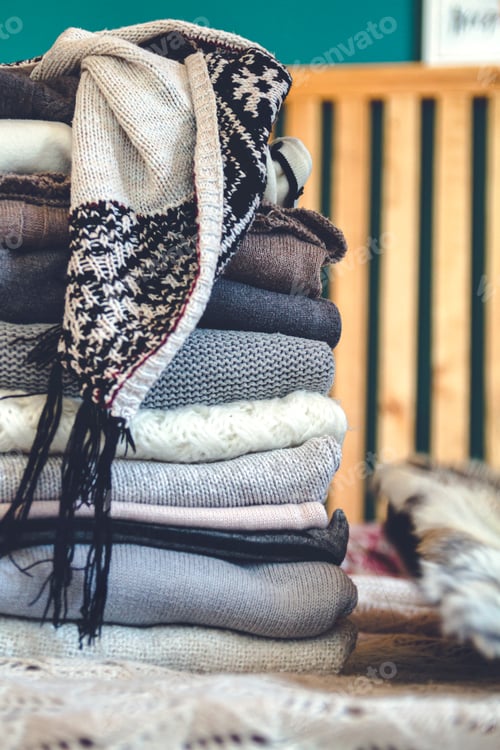 Preview: A stack of cozy warm winter clothes lies on the bed
