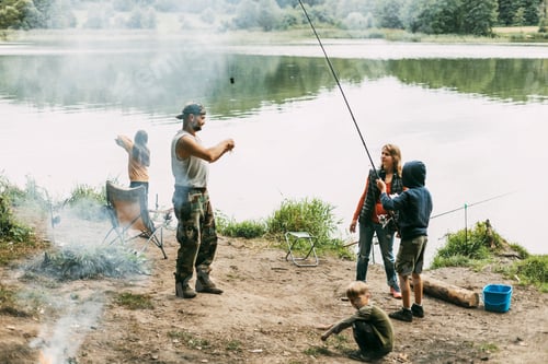 Preview: A happy family is fishing on the bank of a river or lake. Spending time together, family time