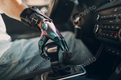 Preview: Young disabled man driver with artificial prosthetic hand driving vehicle car and switches gearbox.