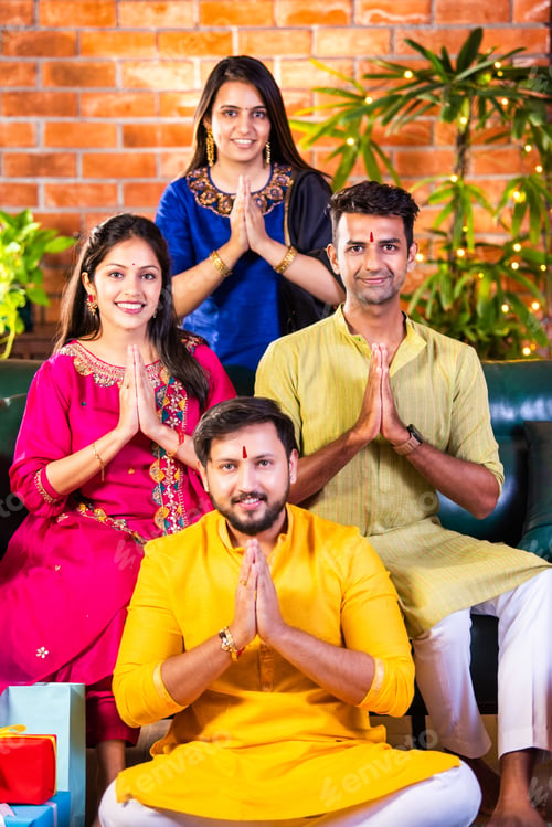 Preview: Happy Indian couples in traditional attire celebrating Diwali, greeting guests with a warm Namaste