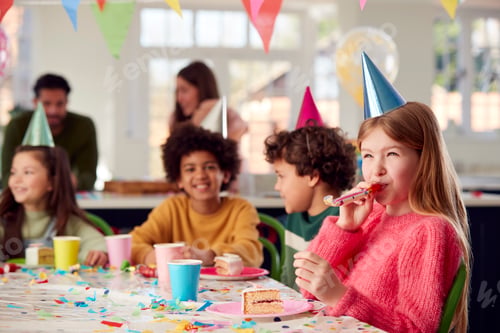 Preview: Girl With Birthday Cake And Party Blower At Party With Parents And Friends At Home