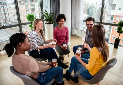 Preview: Diverse group of people sitting in circle in group therapy session.