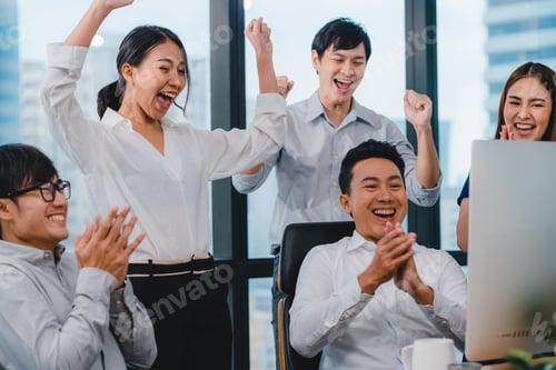 Preview: Millennial group of young businesspeople celebrate giving five after dealing feeling happy