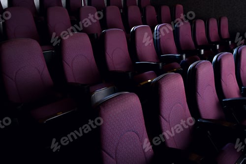 Preview: red seats in empty dark movie theater