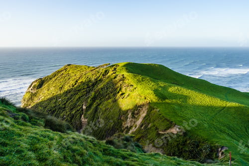 Preview: Beautiful coastal landscape with green rolling hills and cliffs at Cape Farewell
