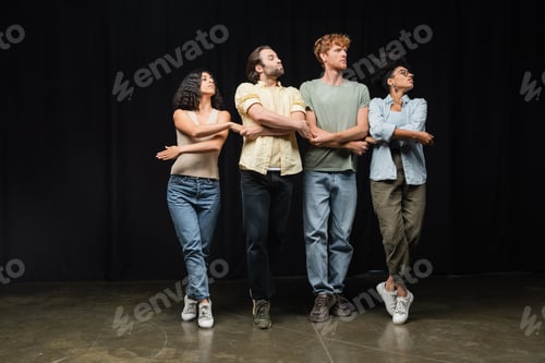 Preview: full length of young interracial actors rehearsing small swans dance in acting school