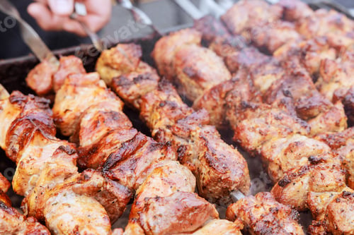 Preview: Traditional Turkish kebab grilling on a hot grill with skewers in great outdoors