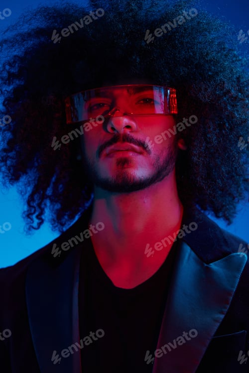 Preview: Fashion portrait of a man with curly hair on a blue background wearing red sunglasses, multinational