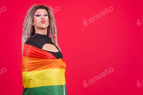 Preview: Transgender person kissing while wrapping with a rainbow lgbt flag
