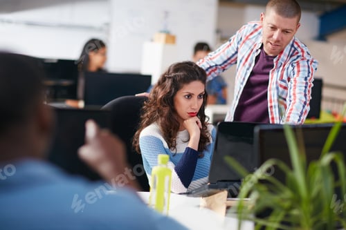 Preview: Shot of two coworkers using a computer together in a modern office