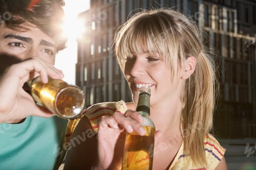 Preview: Germany, Cologne, Young couple drinking beer bottle, smiling