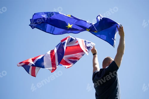 Preview: UK England Flag and European Union EU Flag holded by a man.