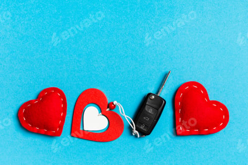 Preview: Top view of gift box, car key, wooden and textile heart on colorful background.