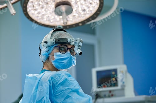 Preview: Close up portrait of female surgeon doctor wearing protective mask and hat during the operation
