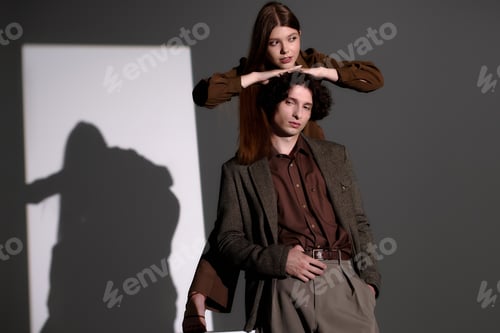 Preview: Stylish young couple radiates confidence in trendy outfits against a grey backdrop