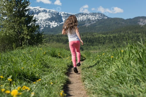 Preview: Rear view of girl having fun in field