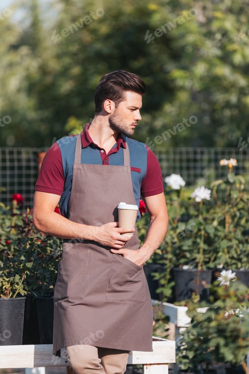 Preview: portrait of pensive gardener with coffee to go looking away while standing in garden