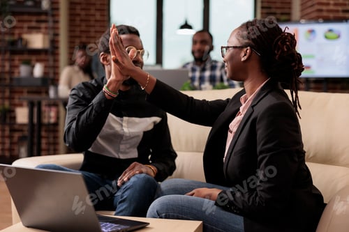 Preview: Team of colleagues giving highfive in office