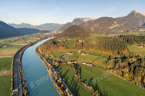 Preview: Aerial view of highway interstate road with fast moving traffic near big river in Alps mountains