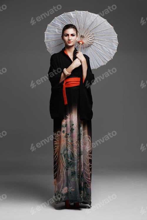 Preview: Demure beauty. Studio fashion shot of a young woman wearing oriental-style clothing.