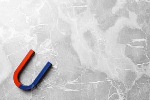 Preview: Red and blue horseshoe magnet on grey marble background, top view. Space for text