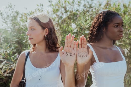 Preview: Two women are showing their palms with writing "Stop Racism" on their hands