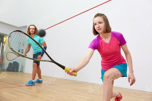 Preview: Young sportive couple practicing squash at indoor court