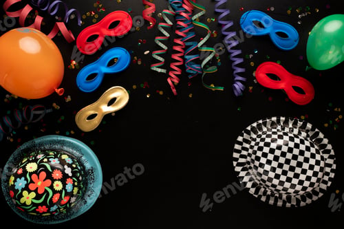 Preview: Carnival objects on a black background. Coiled streamers, masks, hats, paper skeleton, confetti
