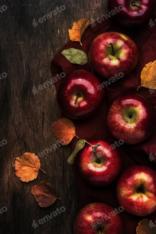 Preview: Autumn food background. Ripe apples with fallen leaves on rustic wooden table