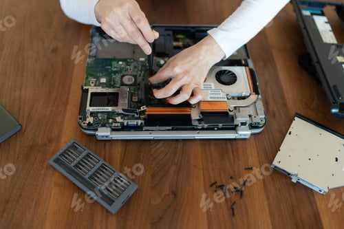 Preview: Woman electronic technician unscrews laptop