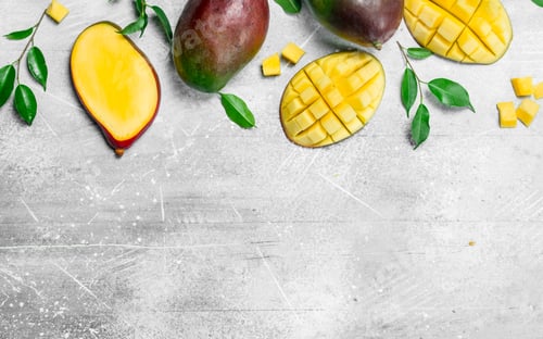 Preview: Whole and pieces of ripe mango with leaves.