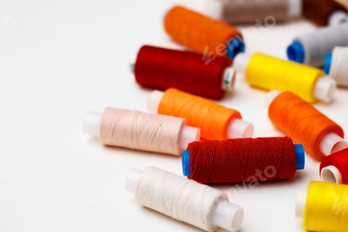 Preview: Colored spools of threads on white background