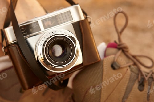 Preview: Vintage camera with hiking boots on the ground. Travel background