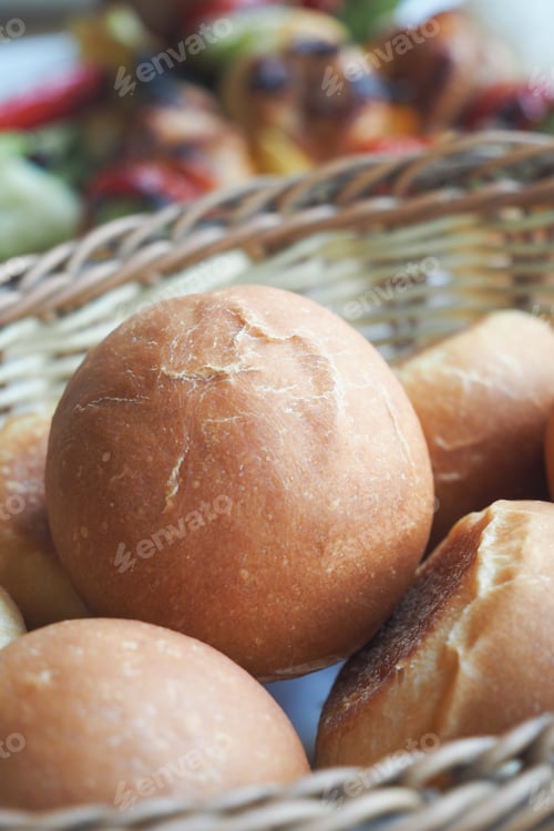 Preview: Freshly baked round bread rolls in a woven basket