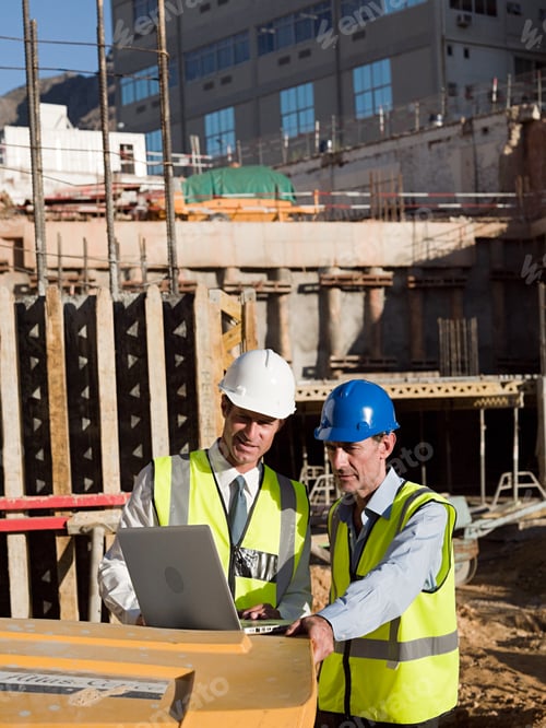 Preview: Mature men uusing laptop on construction site