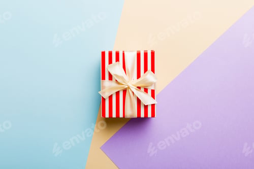 Preview: holiday paper present tied yellow ribbon bow top view with copy space. Flat lay holiday