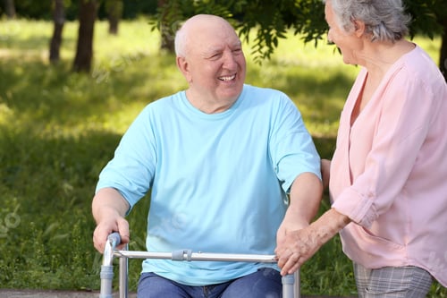 Preview: Elderly woman helping her husband with walking frame outdoors