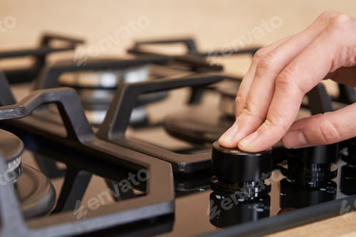 Preview: Female hand use gas stove control panel