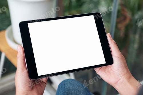 Preview: Mockup image of hands holding black tablet pc with blank white screen while sitting in cafe