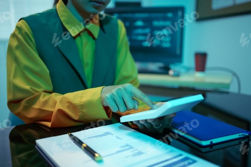 Preview: An Asian businesswoman analyzes digital charts on a computer screen, reviewing performance reports