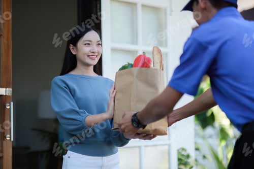 Preview: delivery man Deliver a paper bag package to the beautiful woman at the front of the house according