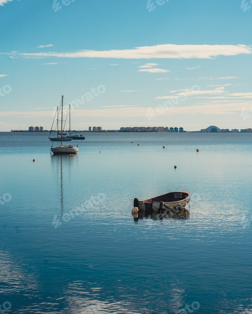 Preview: three small boats in the middle of a calm lake with water reflections