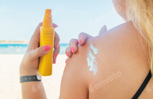 Preview: The girls on the beach wear sunscreen on their skin. Selective focus.