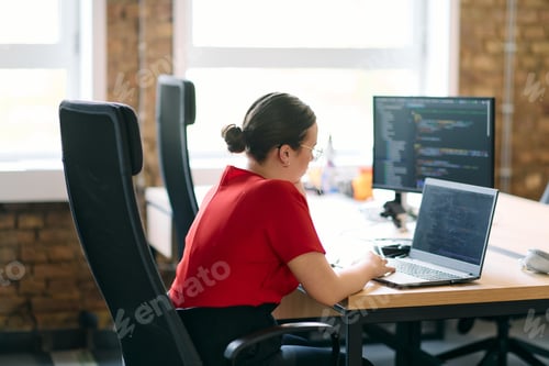Preview: In a contemporary office setting, a young businesswoman is focused on her laptop, displaying