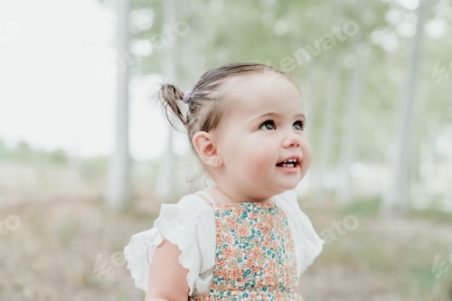 Preview: close up portrait of beautiful happy girl having fun outdoors in trees path.Children, fun and nature