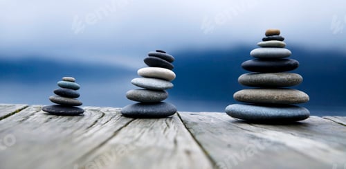 Preview: Zen balancing pebbles next to a misty lake.