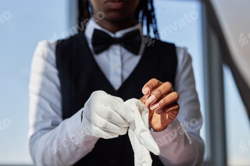 Preview: Young Adult Black Woman Adjusting Gloves during Restaurant Work Shift