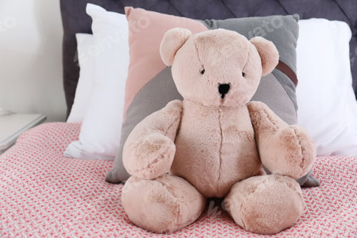Preview: Cute teddy bear sitting on bed indoors