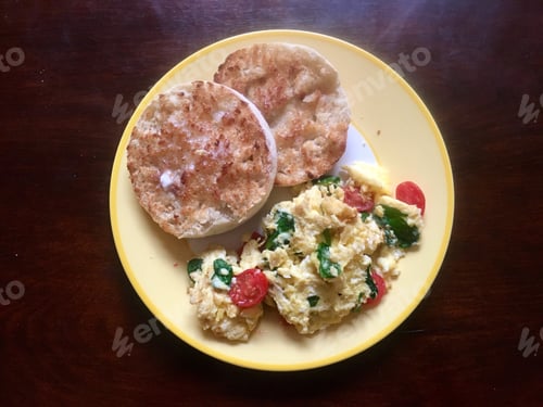 Preview: Overhead shot of scrambled eggs and vegetables with English muffin
